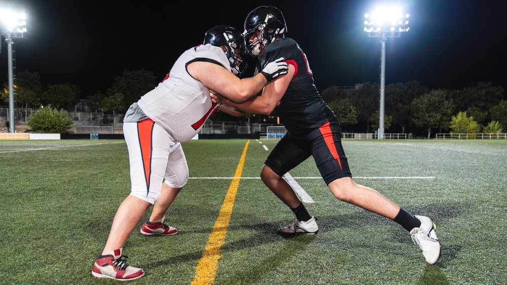 Zwei Footballspieler im direkten Zweikampf an der Line of Scrimmage