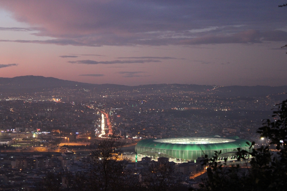 Luftbild von Bursa in der Dämmerung mit dem beleuchteten Stadion, Spielort der Partie Türkei gegen Italien