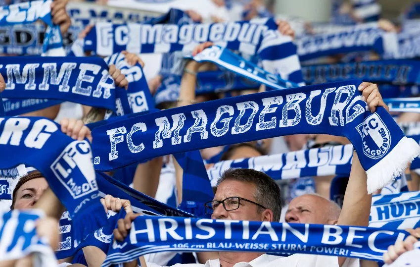 Fans des 1. FC Magdeburg mit Vereinsschals bei einem Heimspiel