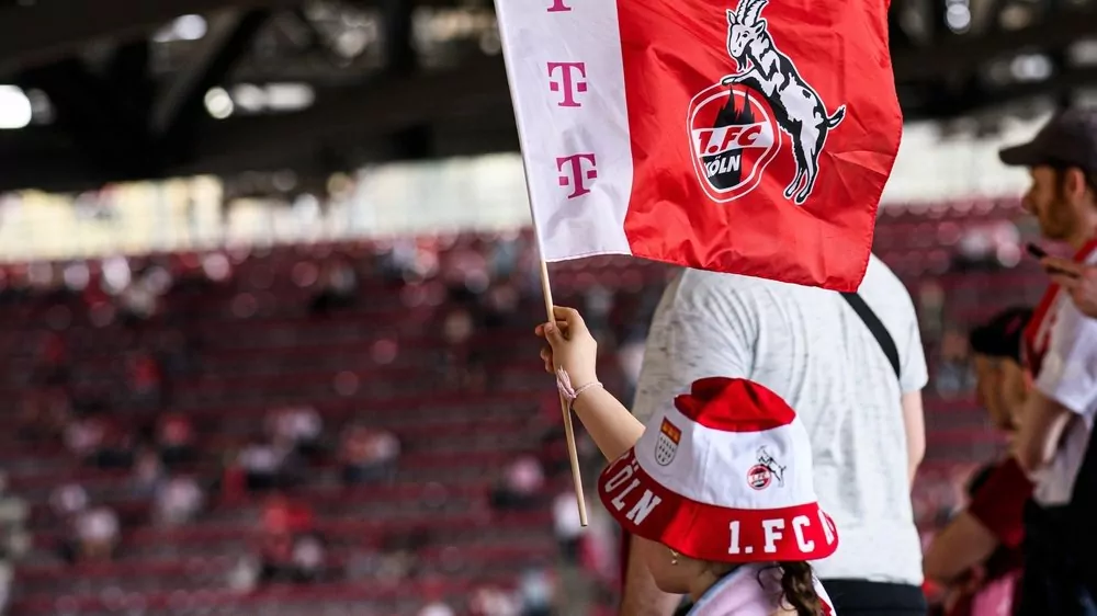 Fans des 1. FC Köln mit Vereinsfahne im Stadion vor dem Derby gegen Gladbach
